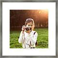 Young Woman Taking Photograph With Camera Against Sunset Framed Print