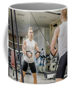 Handsome blond young man exercising pecs on gym equipment Fleece