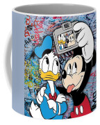 https://render.fineartamerica.com/images/rendered/small/frontright/mug/images/artworkimages/medium/3/donald-duck-and-mickey-mouse-selfie-disney-3-tony-rubino.jpg?transparent=0&targetx=234&targety=0&imagewidth=332&imageheight=333&modelwidth=800&modelheight=333&backgroundcolor=9EB0C9&orientation=0&producttype=coffeemug-11&imageid=33491228