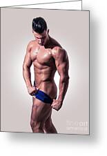 Muscular man pulling down underwear in studio Photograph by