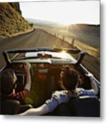 Young Couple Driving Convertible At Sunset Metal Print
