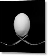 White Egg  Resting On Two Metal And Shiny Forks On A Black Backg Metal Print