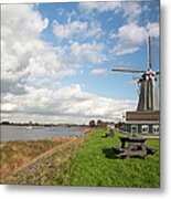 Dutch Windmill On Bank Of River Metal Print