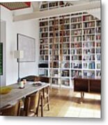 Floor-to-ceiling Bookcase With Wooden Library Ladder Under Sloping Ceiling; Long Wooden Table And Upholstered Chairs In Foreground Metal Print