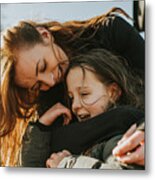 A Mother Bends Down To Embrace Her Daughter From Behind Metal Print