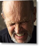 A Wrinkle Faced Balding Elderly Man Wearing A Dark Shirt Scrunches Up His Face While Closing His Eyes And Grimacing Metal Print