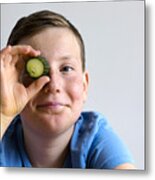 Boy Holding Cucumber Over Eye Metal Print