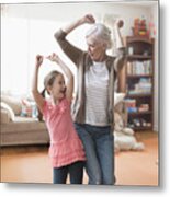 Caucasian Grandmother And Granddaughter Dancing In Living Room Metal Print