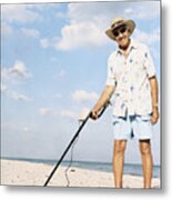 Portrait Of A Senior Man Standing On A Beach Holding A Metal Detector Metal Print