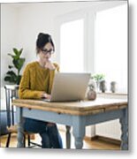 Woman Sitting At Table, Using Laptop Metal Print