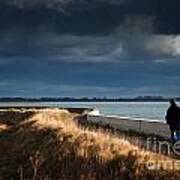 One Man Walking Alone By Sea Wall In Sunshine On Dramatic Stormy Poster