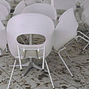 Plastic Chairs Around Tables In A Poster