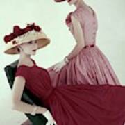 Two Models Wearing Red Dresses Poster