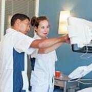 Two Nurses Checking Monitor On Hospital Bed Poster