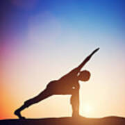 Woman Standing In Revolved Side Angle Yoga Pose Meditating At Sunset Poster