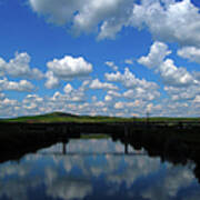 Cumulus Clouds Reflecting Over River Poster