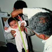 Doctor Measuring The Height Of Baby Held By Father Poster