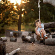 Playful Boy Swinging On Rope Swing At Park Poster