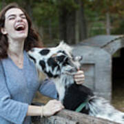 Pretty Teenage Girl Laughing While Petting Goat In Farm Setting Poster