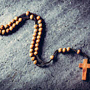 Wooden Rosary Laying On Stone Background. Poster