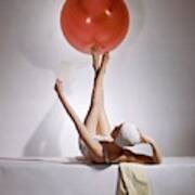 A Model Balancing A Red Ball On Her Feet Art Print