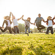 Group Of People Jumping On The Park At Dusk Art Print