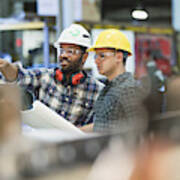 Multi-ethnic workers talking in metal fabrication plant Art Print