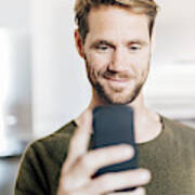Portrait Of Smiling Man Looking At Cell Phone Art Print