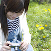 Woman Smiling And Holding A Digital Camera On Lawn, Front View, Japan Art Print