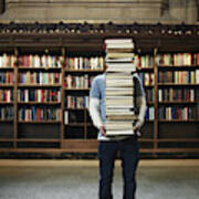 Young Man Carrying Stack Of Books In University Library Art Print