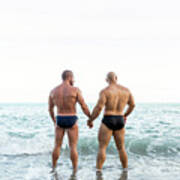 Lgbt Pride Concept. Muscled Gay Bear Couple Standing Back On The Shore Of The Beach. Holding Hands And Looking To The Seascape. Art Print