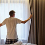 Man Opening Curtains In Hotel Room Art Print
