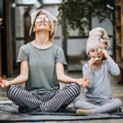Relaxed mother and daughter exercising Yoga in the morning at home. Art Print