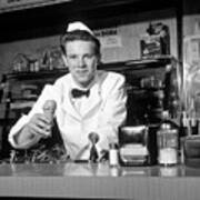 1950s Smiling Young Man Soda Jerk Leaning Across Counter Looking At Camera Serving Ice Cream Cone Art Print