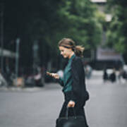 Confident Businesswoman Using Smart Phone While Crossing Street In City Art Print