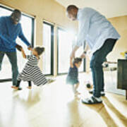 Laughing Grandfather And Father Dancing With Granddaughter And Daughter In Living Room Art Print