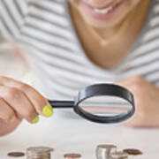 Mixed Race Woman Examining Stacks Of Coins With Magnifying Glass Art Print