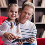 Smiling Girl Resting With Her Grandfather And Holding The Tablet Art Print