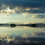 Two Islands And The Cloudy Sky Are Reflected In A Glassy Lake Art Print