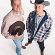 Two Young Adult Caucasian Cowboys Wearing Boots Are Standing Beside Each Other One Holding A Hat And One Wearing A Hat Art Print