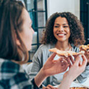 Two Young Women Eating Pizza Together At Home. Art Print