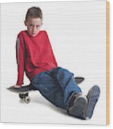 A Caucasian Boy In Jeans And A Red Sweater Sits On His Skateboard And Smiles Slightly Wood Print