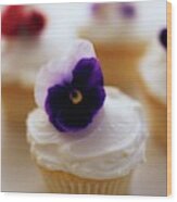 A Cupcake With A Violet On Top Wood Print