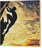 A Silhouette Of Man Free Climbing On Rock Mountain At Sunset Wood Print