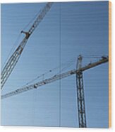 Construction Cranes Against A Blue Sky Wood Print