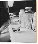 Glass Of Water And Bottles Of Pills On Bedside Table Of Early Twenties Woman Waking In Bed In A Bedr Wood Print
