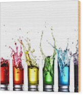 Glasses Of Colorful Liquid Splashing Wood Print