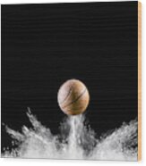 Impact And Rebound Of A Ball Of Basketball On A Surface Of Land And Powder On A Black Background Wood Print