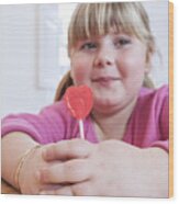 Portrait Of Overweight Girl Holding Heart Shape Lollipop Wood Print