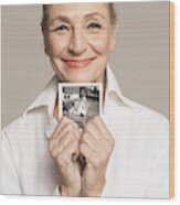 Senior Woman Holding Photo Of Her Younger Self Wood Print